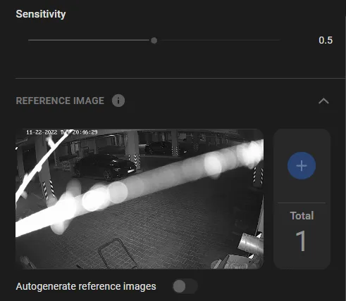 The TamperTrack detector settings panel showing a sensitivity slider at 0.5, a stored reference image of a parking garage bay with a bright floodlight streak across it, a total count of one reference image and an Autogenerate reference images toggle switched off.